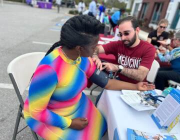 Crystal Clyburn has her blood pressure taken at a table outdoors.