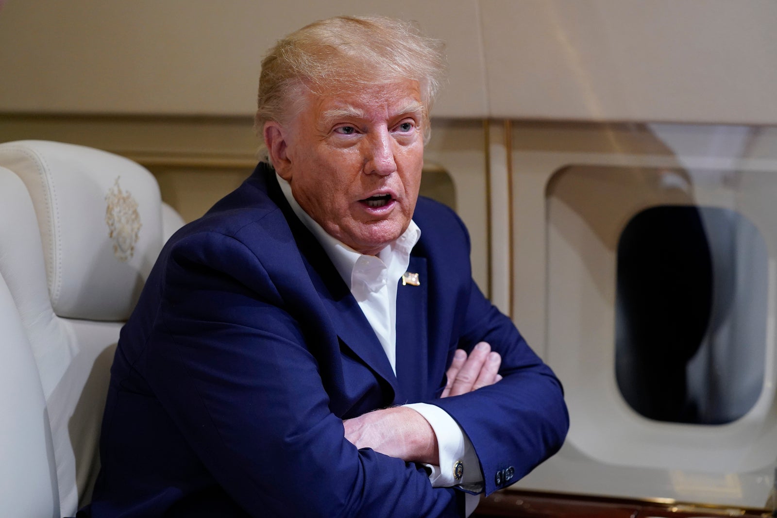 Former President Donald Trump speaks with reporters while in flight