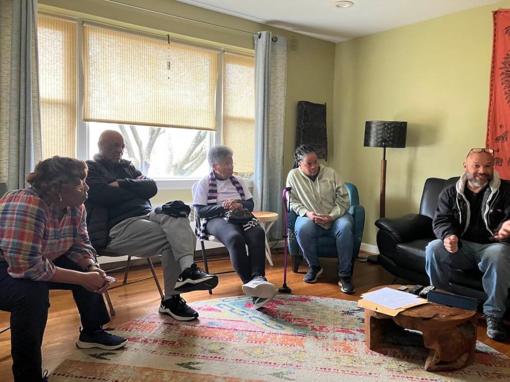 Wynetta Ward sits in a room with several of her neighbors.