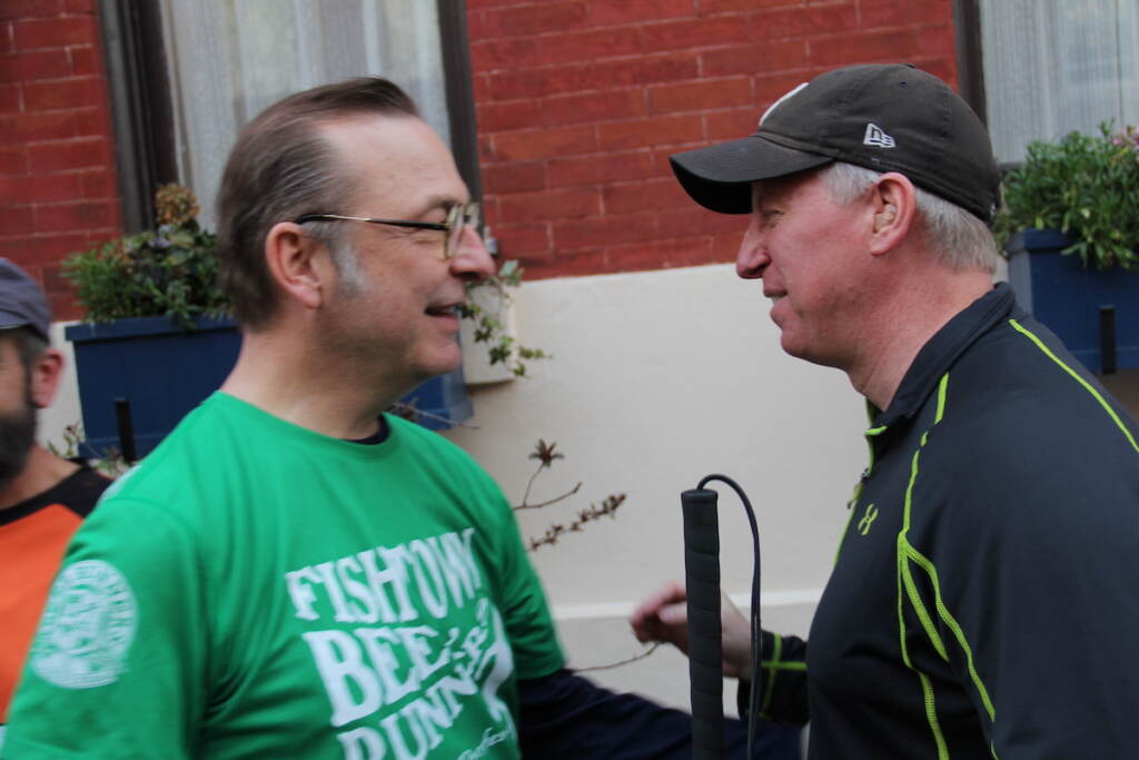 David April and Mark McCowan stand across from each other, smiling.