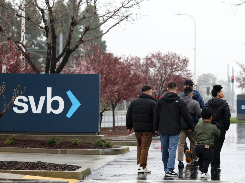 People walk through the parking lot at the Silicon Valley Bank