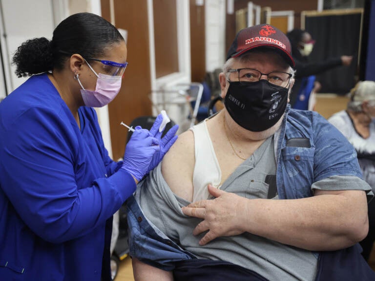 A medical professional gives someone a COVID-19 vaccine.