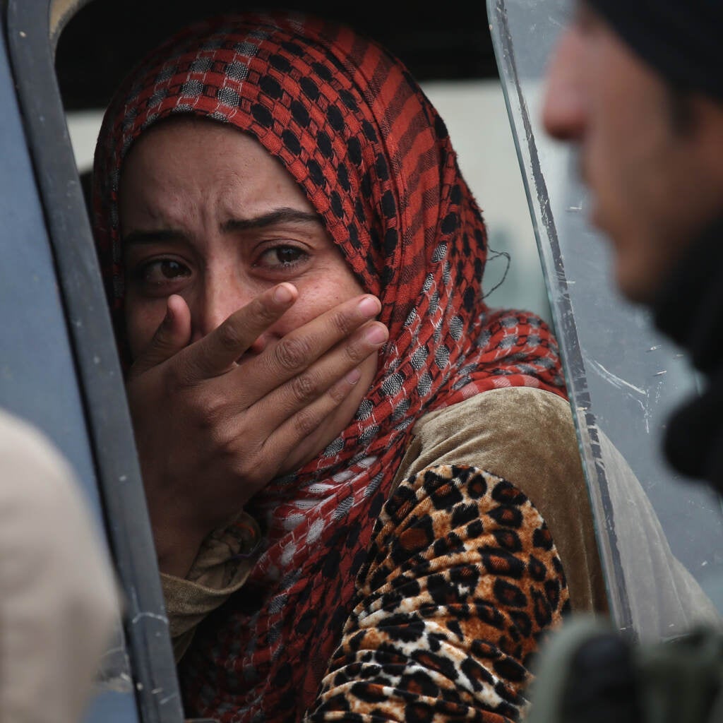 A woman holds her hand over her mouth.