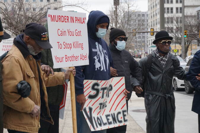 Supporters hold anti-violence signs.