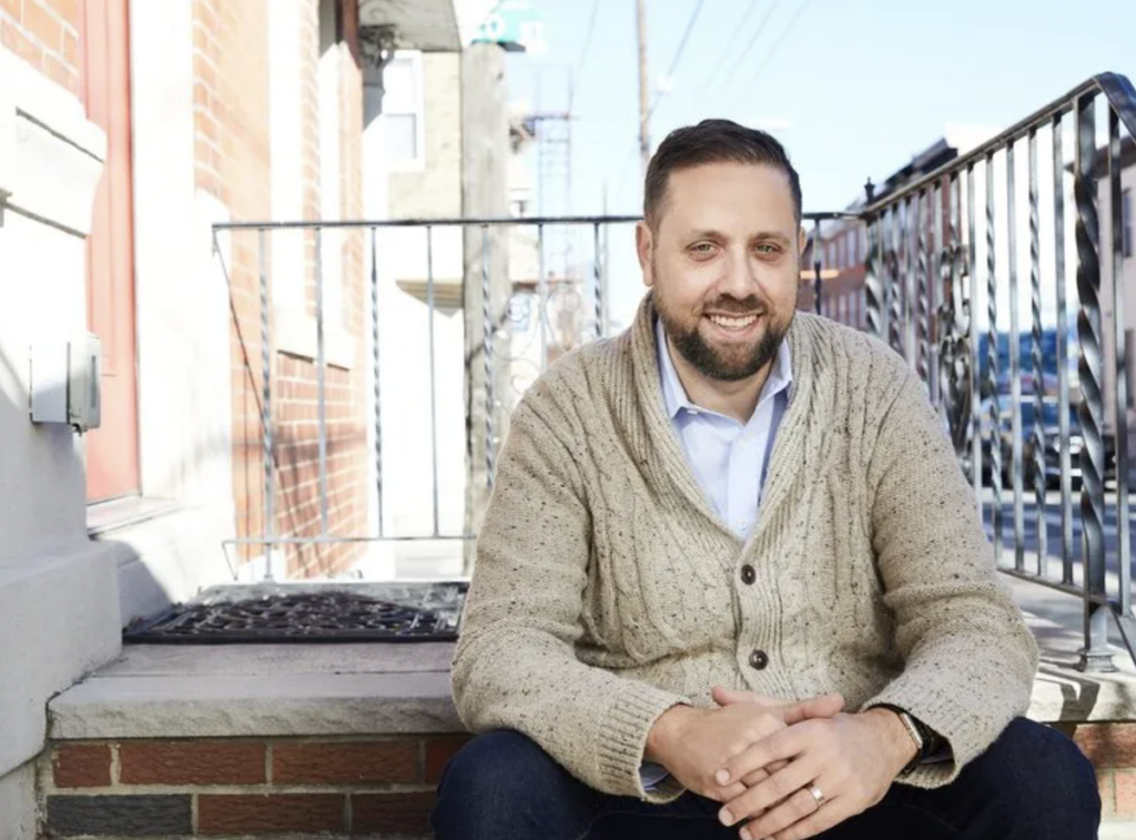 Job Itzkowitz sitting on a front stoop of a rowhome