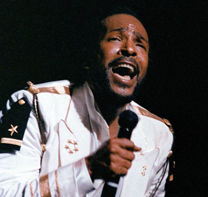 A close-up of Marvin Gaye singing into a microphone.