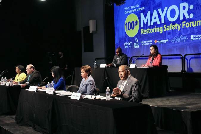 Candidates for Phildelphia mayor are seated in rows on a stage.