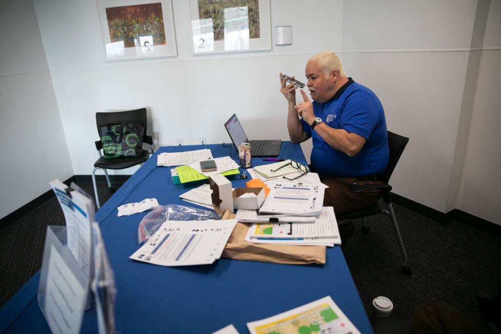 Samuel Camacho, a health insurance navigator with the Universal Health Care Action Network of Ohio, on the phone with a client at the library in Columbus, OH on March 19, 2023. Camacho helps Spanish-speaking residents with their Medicaid paperwork.
