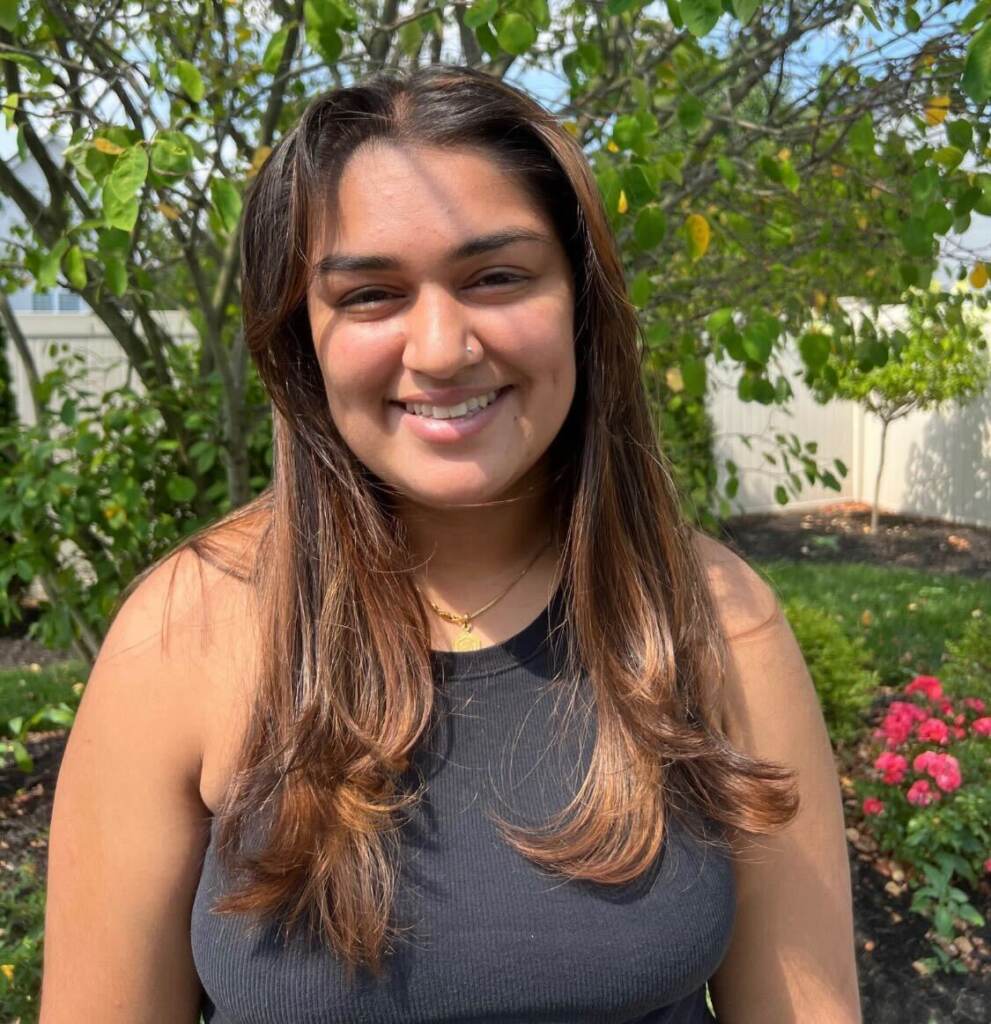 Anjali Darji smiles, posing for a photo outdoors.