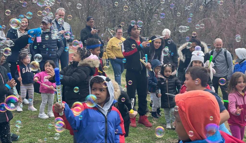 Kids play in a park with bubbles.