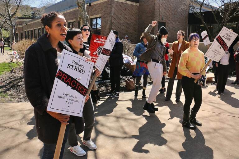 Faculty and staff hold picket signs on the Camden campus of Rutgers University.