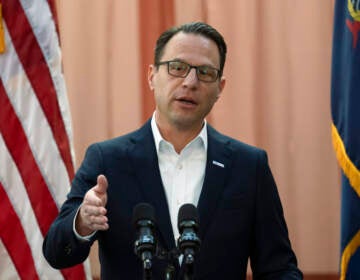 Gov. Josh Shapiro gestures as he speaks at a podium.