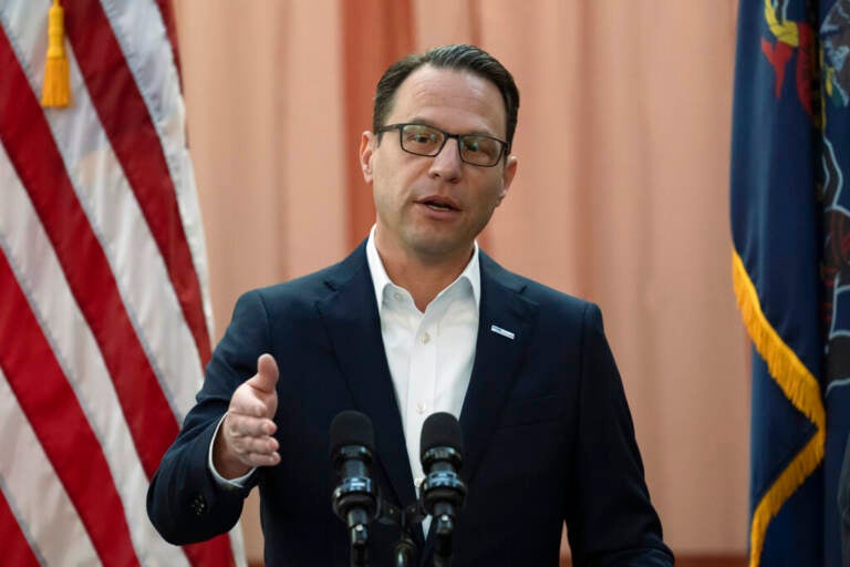 Gov. Josh Shapiro gestures as he speaks at a podium.