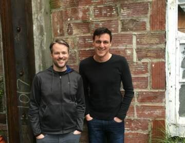 Bede Jordan and Stefan Kalb pose for a photo in front of a brick wall.