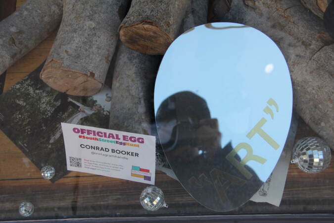An egg design showing a mirror is displayed in a store window.