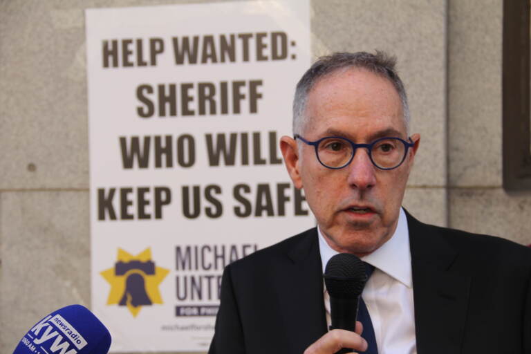 Michael Untermeyer appears with a sign behind him that says ''Help wanted: Sheriff who will keep us safe''