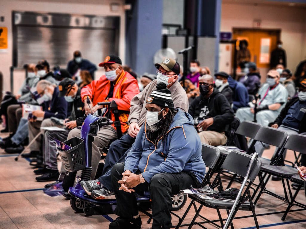 A group of people sit in rows of chairs.