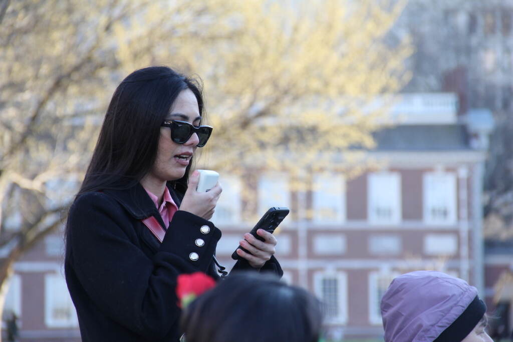 AOPxSola Director Farwa Ahmadi speaks into a microphone.