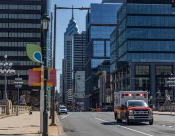 An ambulance driving on a major road in Philly.