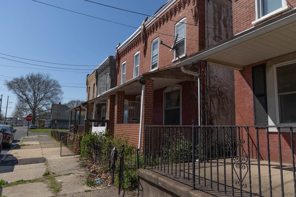 Rowhomes on a street on a sunny day.