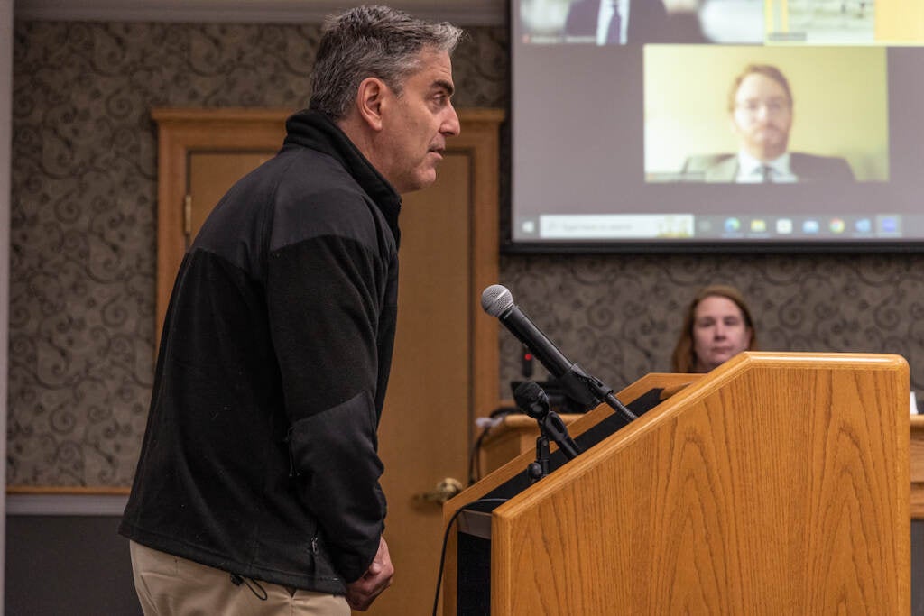 Joe Oxman speaks to the board of commissioners from a podium.