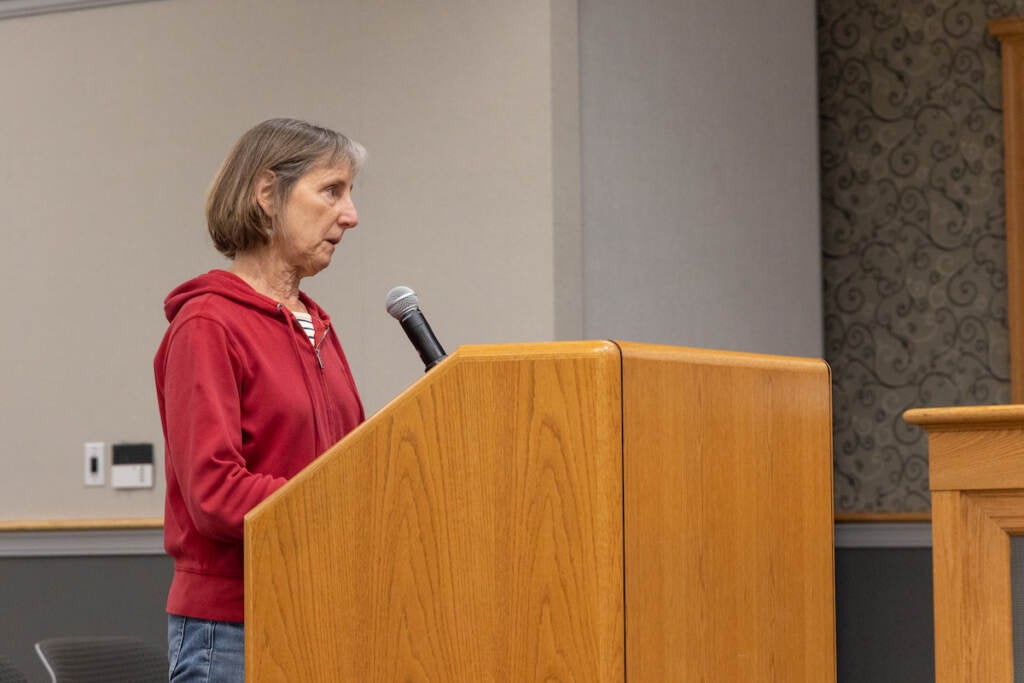 Linda Finkelstein speaks at a wooden podium.