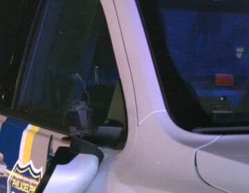 A Philadelphia Police car with it's rear-view mirror detached and other damage.