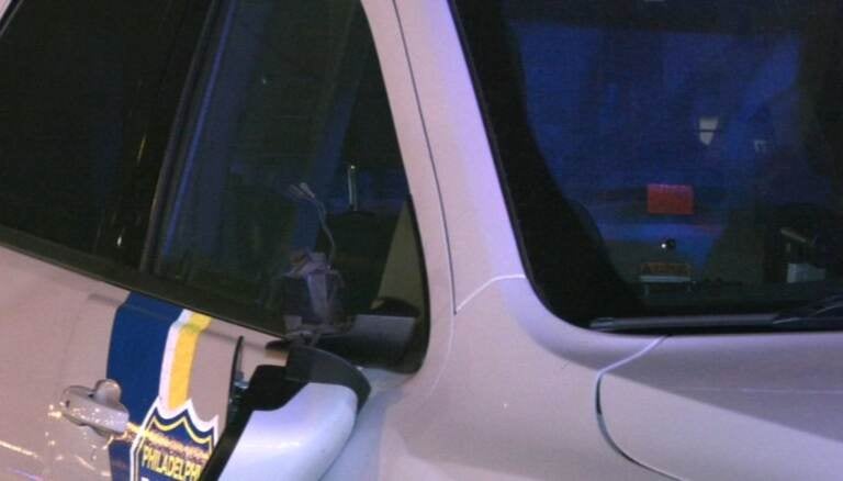 A Philadelphia Police car with it's rear-view mirror detached and other damage.