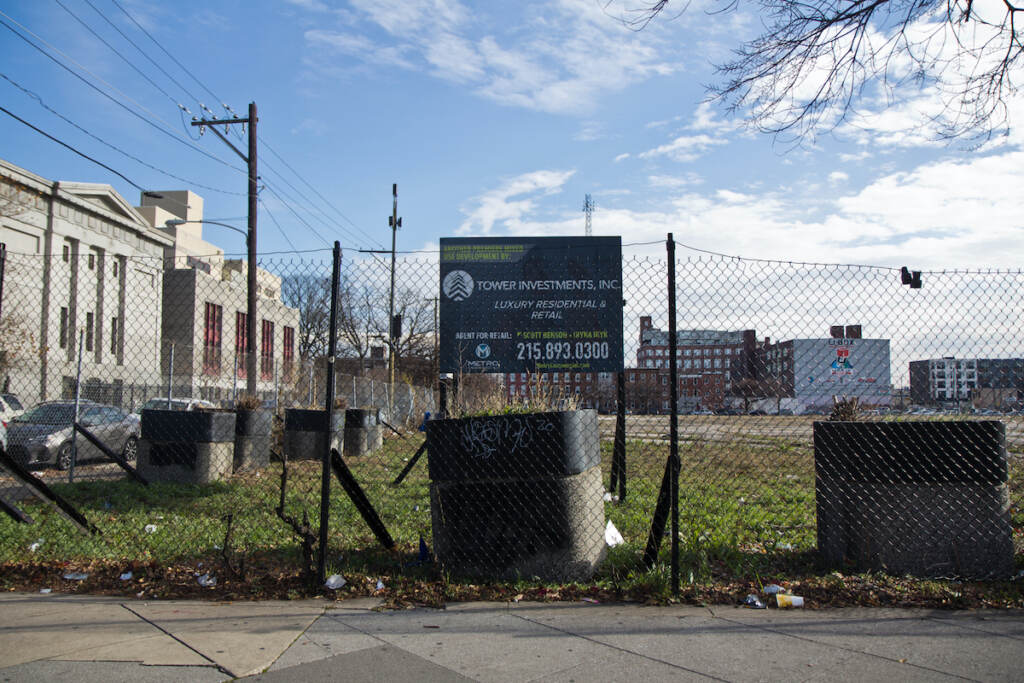 Developer's sign on a fence at a massive vacant lot.