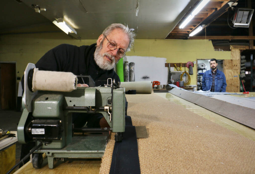 Jerry Amadio wlrking with machinery on a rug.