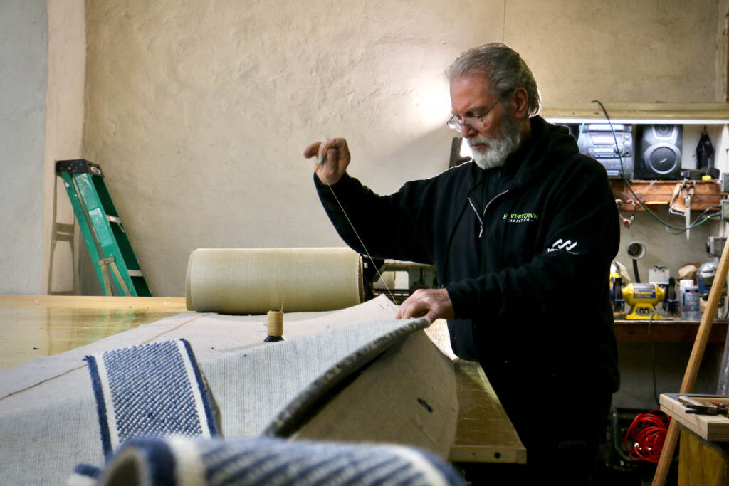 Sewing a rug by hand.