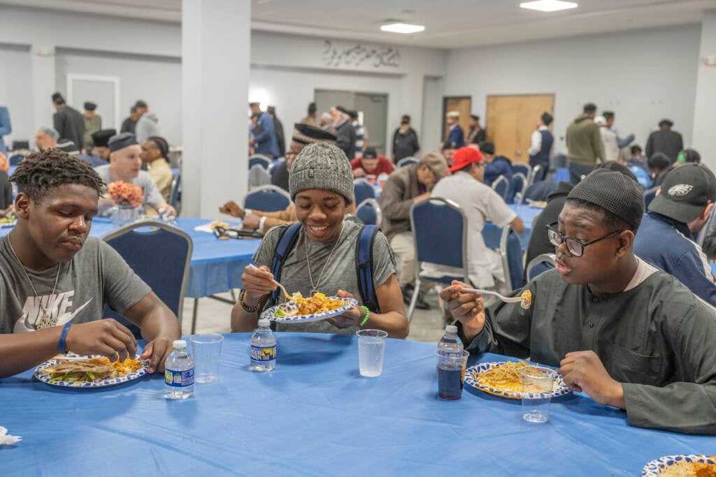 (From left) Hakeem Greer-Gilliam, Rahsaan Mason, and Nahyee Hyman enjoy a meal after breaking the fast at the Baitul Aafiyat Mosque's Interfath Iftar on Saturday evening