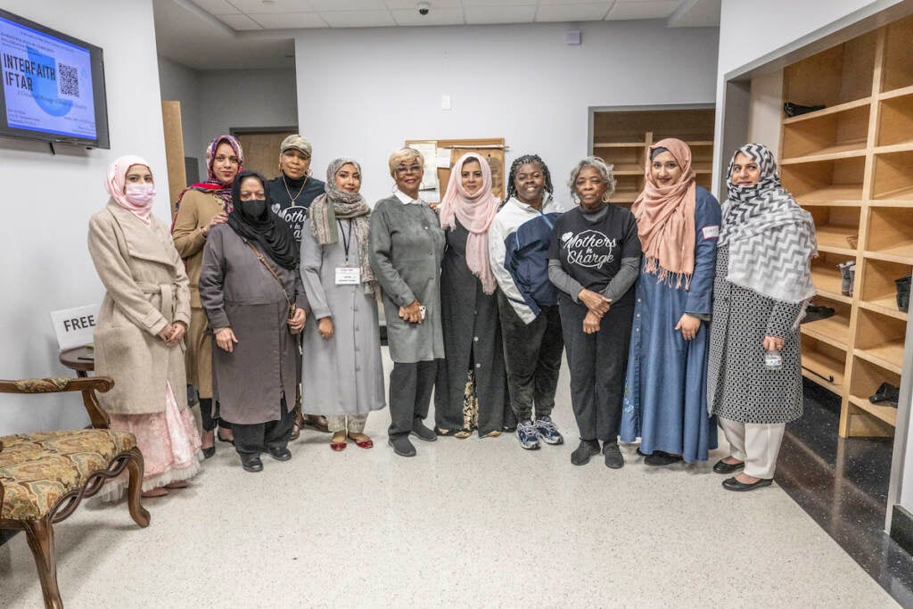 Moms in Charge founder Dr. Dorothy Johnson-Speight (center wearing glasses) stands with Moms in Charge members along with members of Baitul Aafiyat Mosque