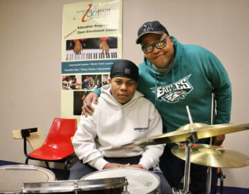 Michael Barnes embraces his 13-year-old son, Elijah, behind a drum set at the Clef Club.