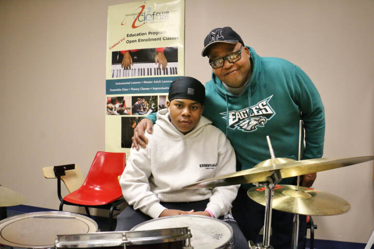 Michael Barnes embraces his 13-year-old son, Elijah, behind a drum set at the Clef Club.