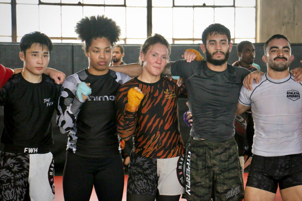 DeAnna Bennett (center) takes a photo with teammates at Marquez MMA Gym in North Philadelphia