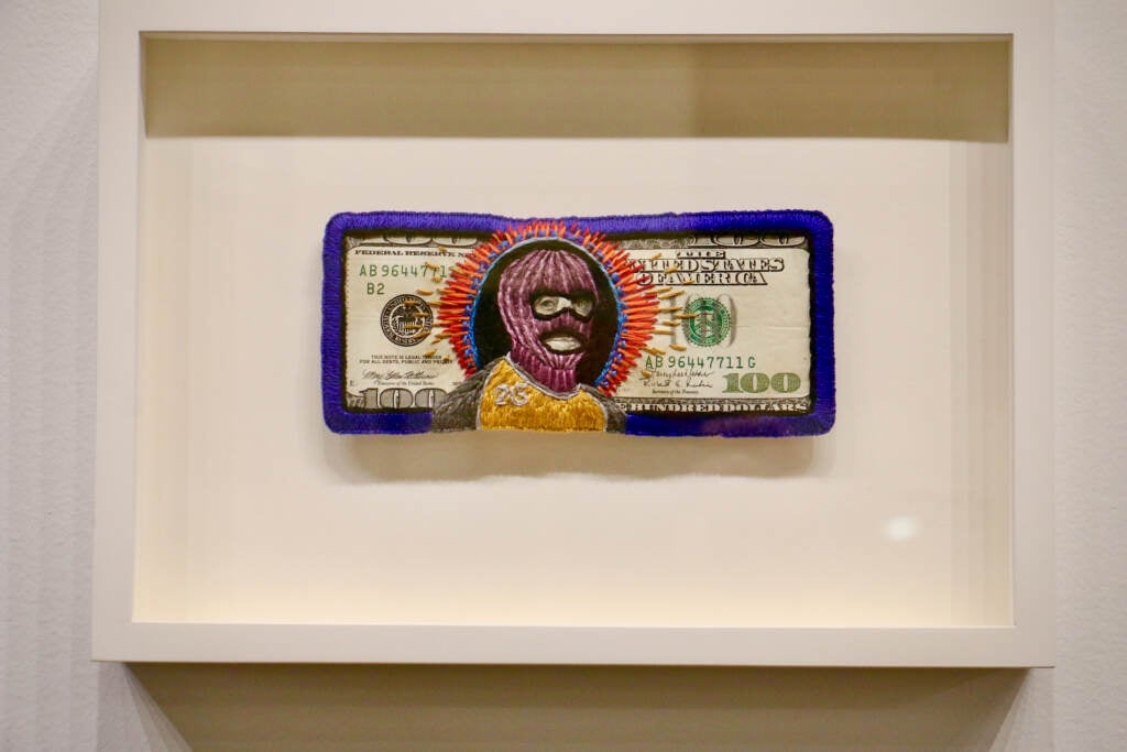 Stacie Lee Weber's embroidered $100 bill, ''Ben Franklin Ski Mask,'' sold for $1,100 at auction. The procedes were donated to support DeAnna Bennett in her quest for the world championship