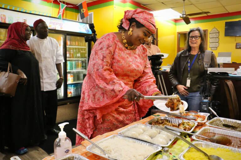 Youma Ba prepares a plate for guests at the launch of Africatown Restaurant Week at the African Small Pot Restaurant on Woodland Avenue