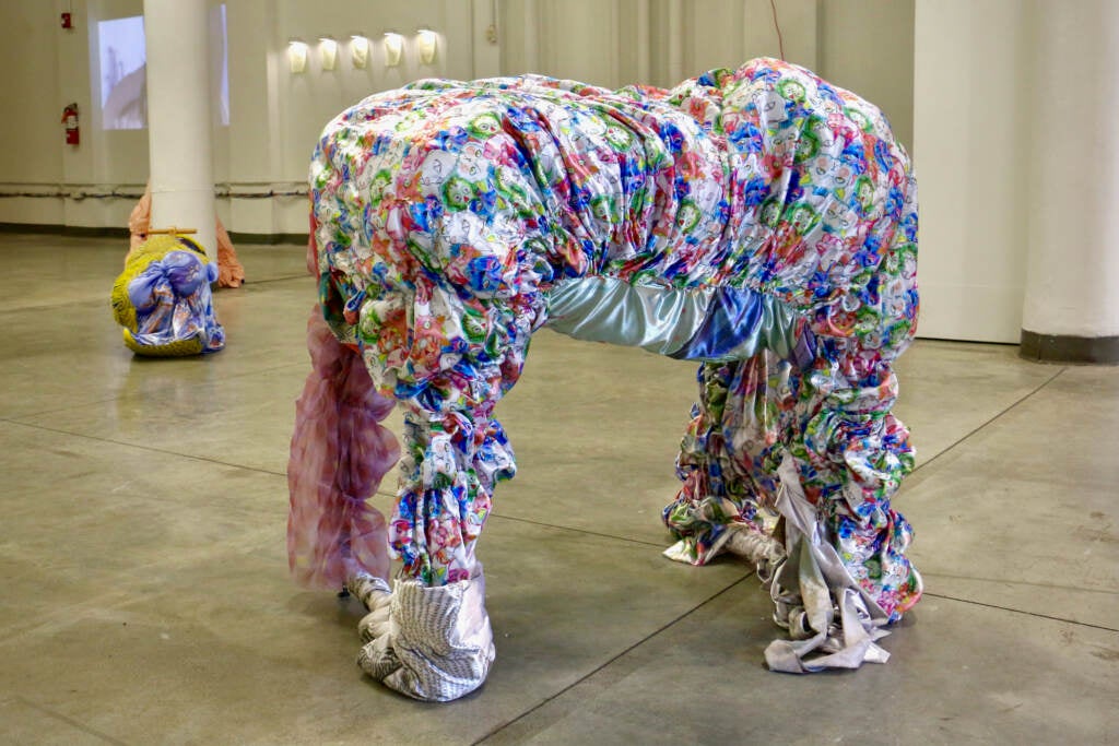 A four-legged sculpture is covered in fabric.