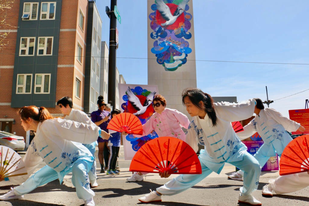 Dancers perform in front of a mural.