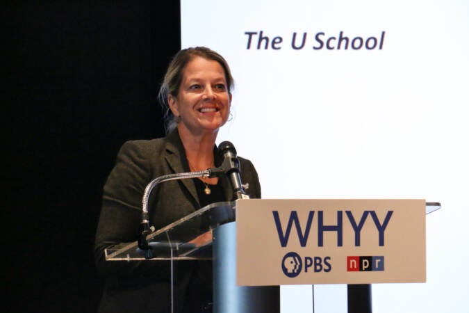 Bethany Wiggin speaks at a podium.