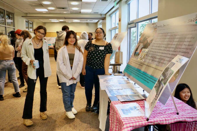 Students (from left) Kai McLean of Kensington CAPA and Nhi Ngo and Katherine Estivez of Girls High, present their projects during a climate storytelling festival at WHYY.