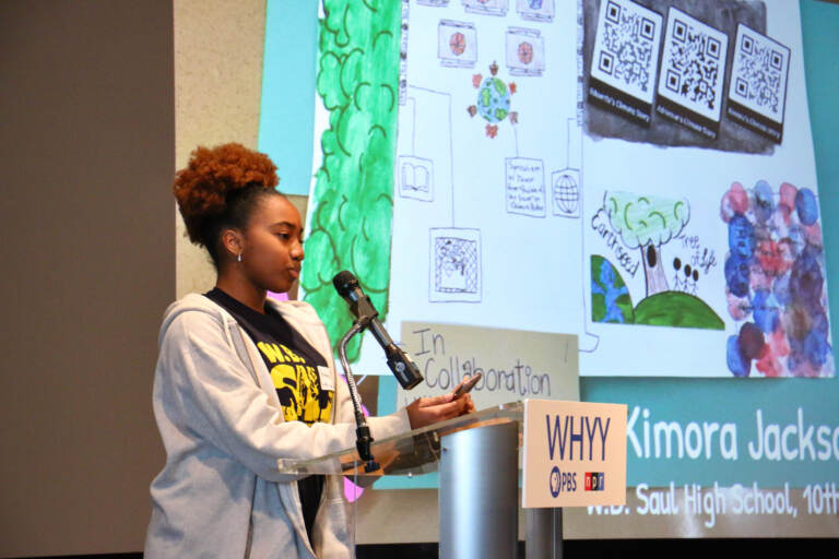 Kimora Jackson speaks at a podium in front of a presentation.