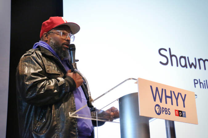 Shawmar Pitts speaks into a microphone at a podium.