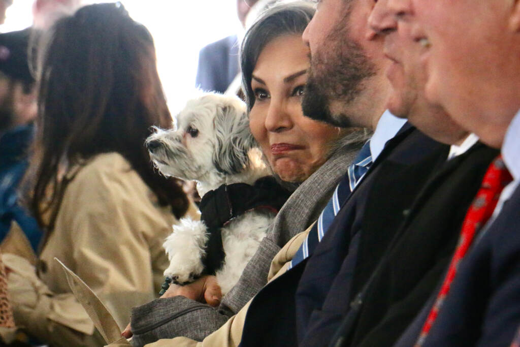 Farrah Houshmand holds her dog, Sophie, as they sit in the crowd.