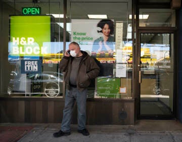 A man waits outside a H&R Block tax preparation office