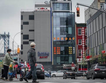 A six story glass facade building, center, is believed to be the site of a foreign police outpost for China in New York's Chinatown, Monday, April 17, 2023. Justice Department officials say two men have been arrested on charges that they helped establish a secret police outpost in New York City on behalf of the Chinese government. (AP Photo/Bebeto Matthews)