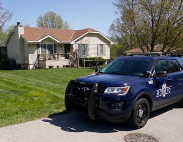 A police officer drives past the house Monday, April 17, 2023, where 16-year-old Ralph Yarl was shot Thursday when he went to the wrong house to pick up his younger brothers in Kansas City, Mo