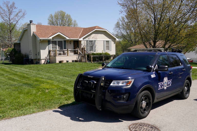 A police officer drives past the house Monday, April 17, 2023, where 16-year-old Ralph Yarl was shot Thursday when he went to the wrong house to pick up his younger brothers in Kansas City, Mo