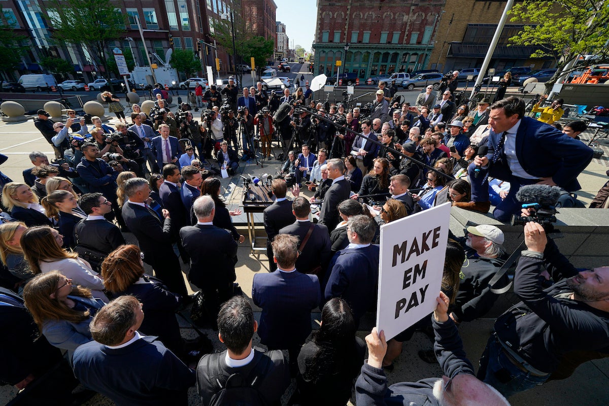 Reporters surround attorneys for Dominion Voting Systems during a news conference outside the New Castle County Courthouse in Wilmington, Del.